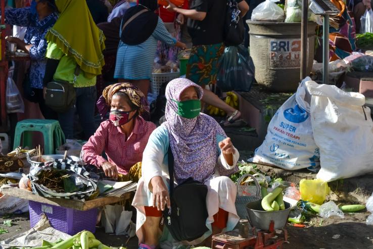 Two women wear face masks while selling their wares in the tradition markets of Temanggung, Central Java, Indonesia