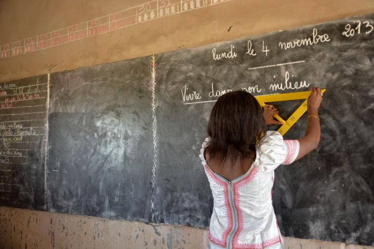 Woman in school writing on a black board