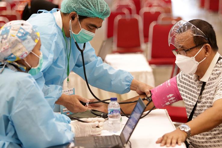 Man has blood pressure checked before receiving Covid-19 vaccine