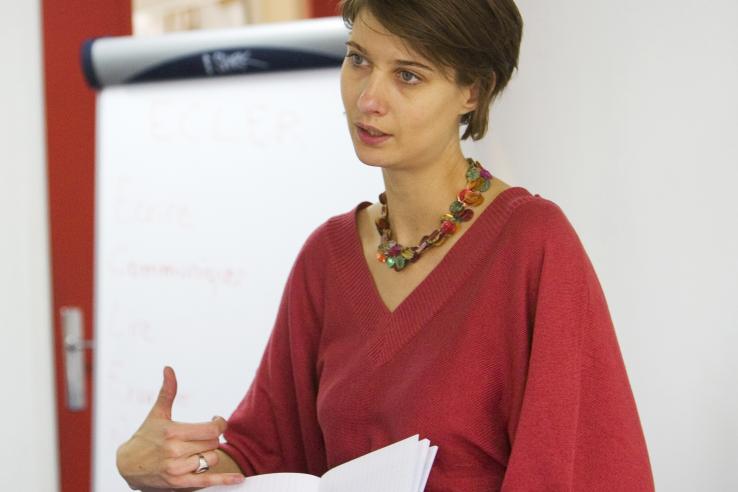 A young woman presents a lesson in a classroom.