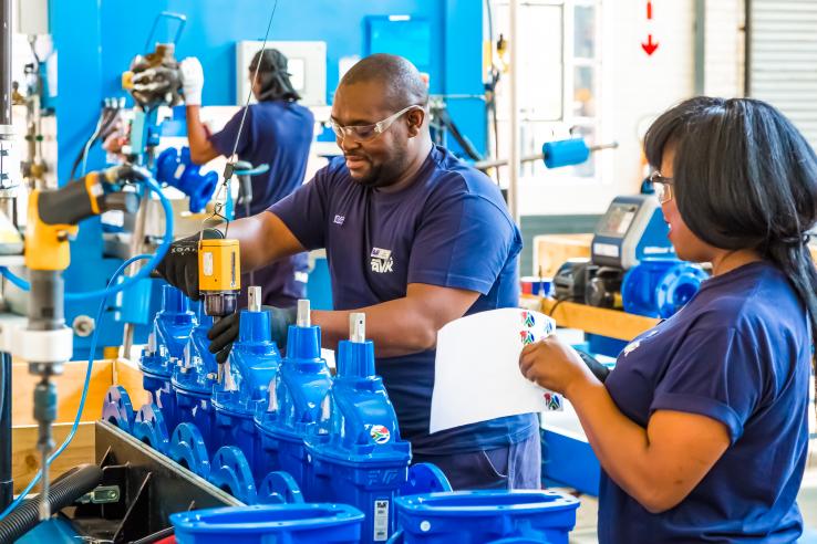 Man and woman work in industrial valve manufacturing and assembly factory