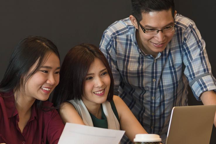 Three young adults working on a project together.