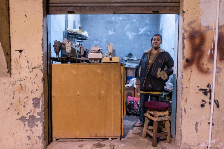 A woman stands just inside her shop