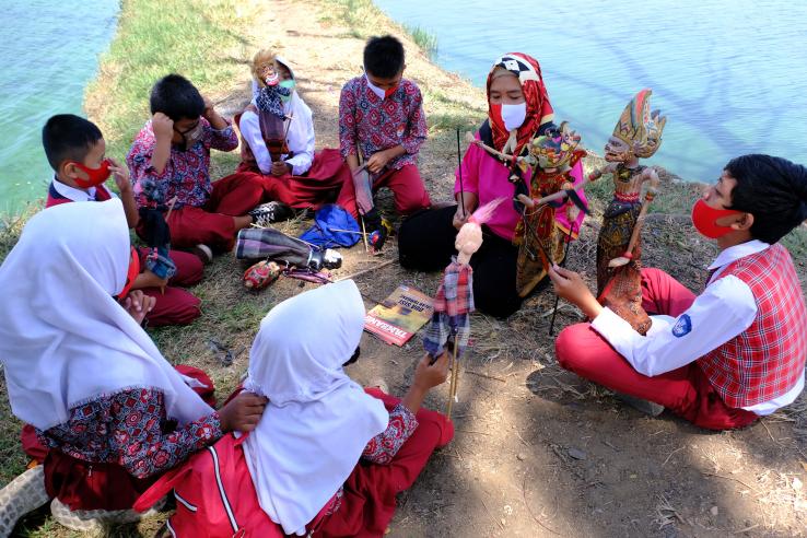 teacher and students learning outdoors during the covid-19 pandemic