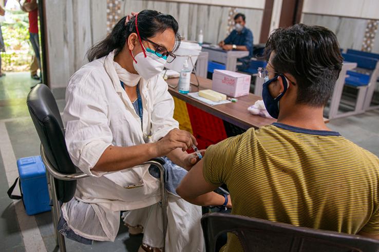 A doctor admistering a Covid-19 vaccine to a man in India