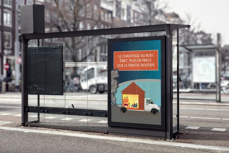 A colorful sign at a bus stop warning people that wood burning emits more CO2 than road traffic