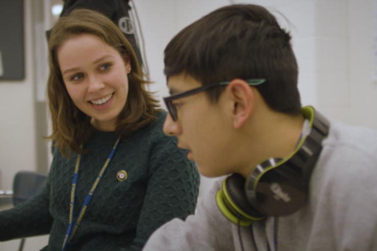 Smiling tutor studies with student