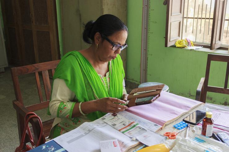A nurse using a tablet for data collection at a clinic in Haryana