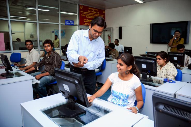 Two people sit in front of a computer screen.