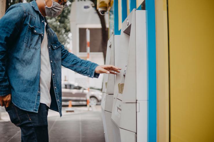 Man reaching out hand to use ATM 