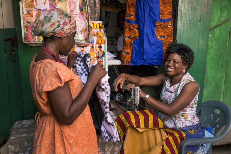 Woman at sewing machine speaking with a customer