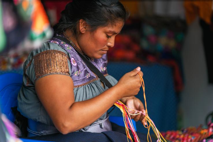 mujer concentrada hilando manto típico, Latinoamérica