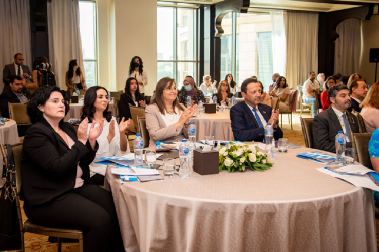 Attendees of the event sit together around a table.