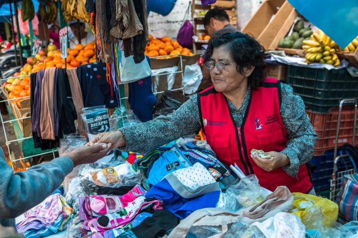 A female worker is selling clothes and earning cash.