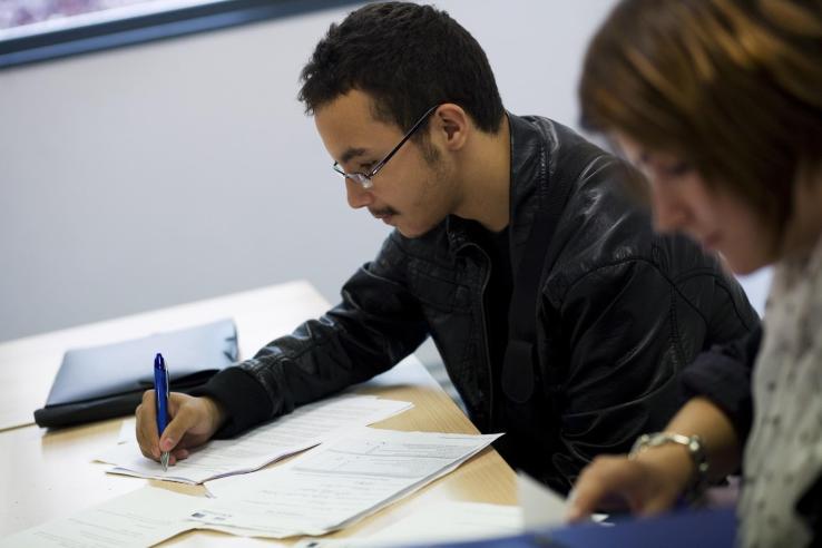 French man working on his CV as part of a youth employment program 