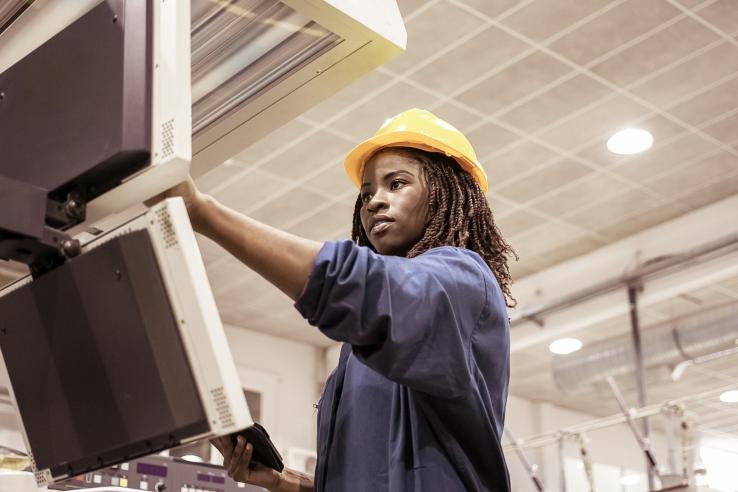 female worker operating industrial machine
