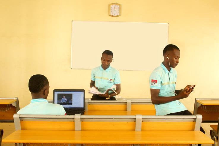 Photo of three male students in classroom doing school work