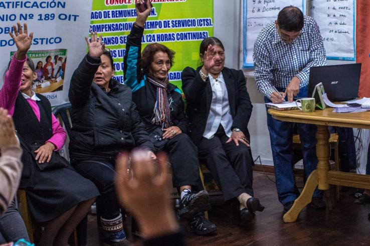 Grupo de personas en una votación a mano alzada