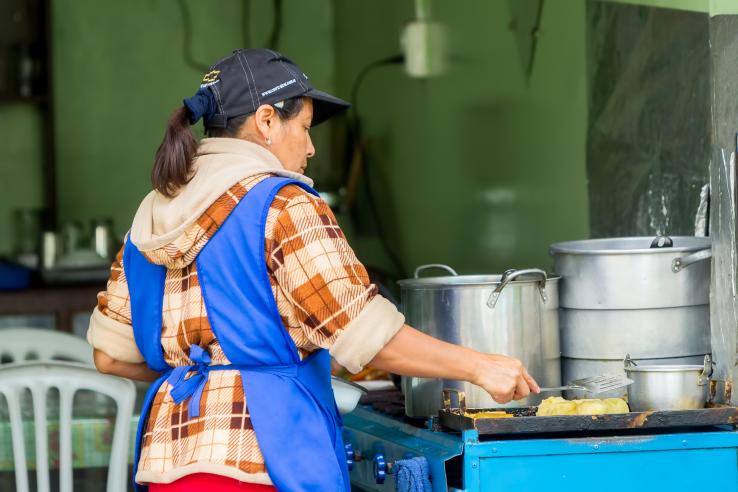 Mujer cocinando en un puesto