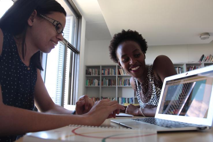 College students sitting with laptops at a desk