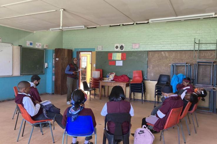 Children sit in circle in classroom