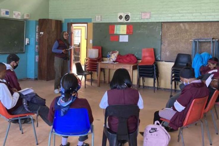 Children sit in circle in classroom