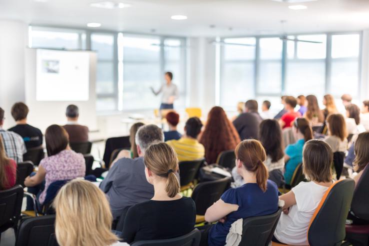 A group of people watching a speaker
