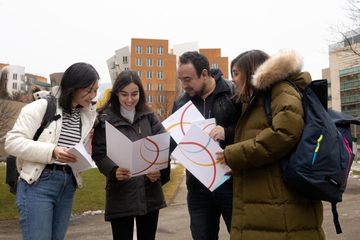 DEDP students look through J-PAL folders while exploring MIT's campus