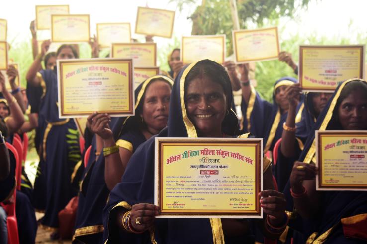 Women in India hold up their diplomas