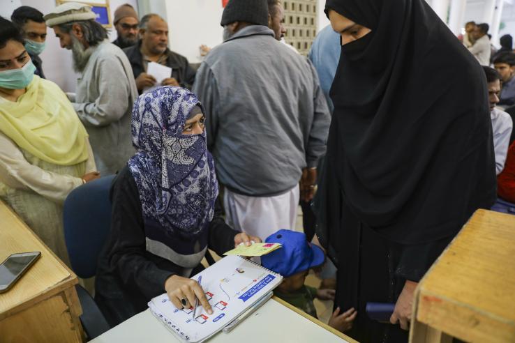 Health worker in Sindh, Pakistan speaks with caregiver at immunization site.