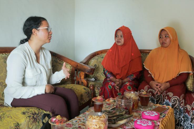 A woman speaks to two other women.