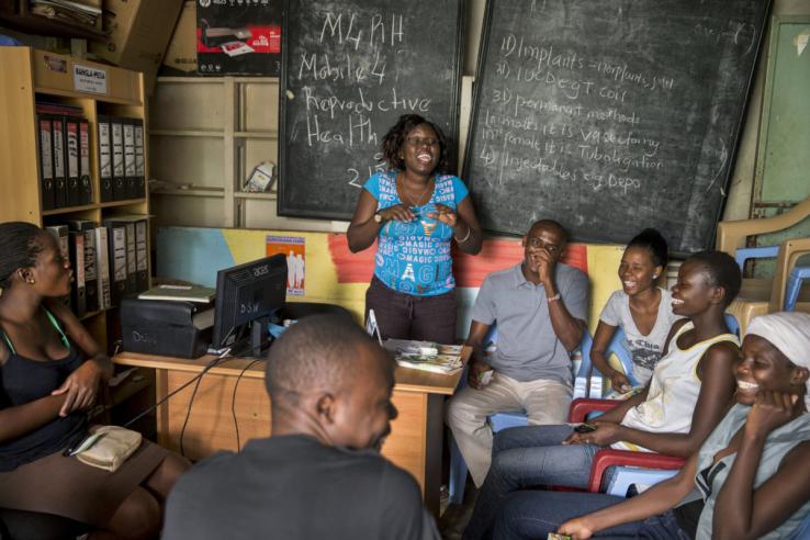 A group of men and women actively engaged during a community outreach on reproductive health