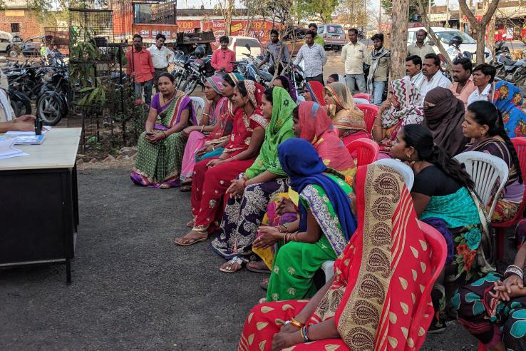 A large group of women in India listen to a government official