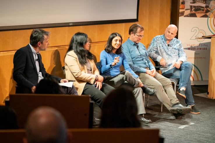 Five people sit on a panel.