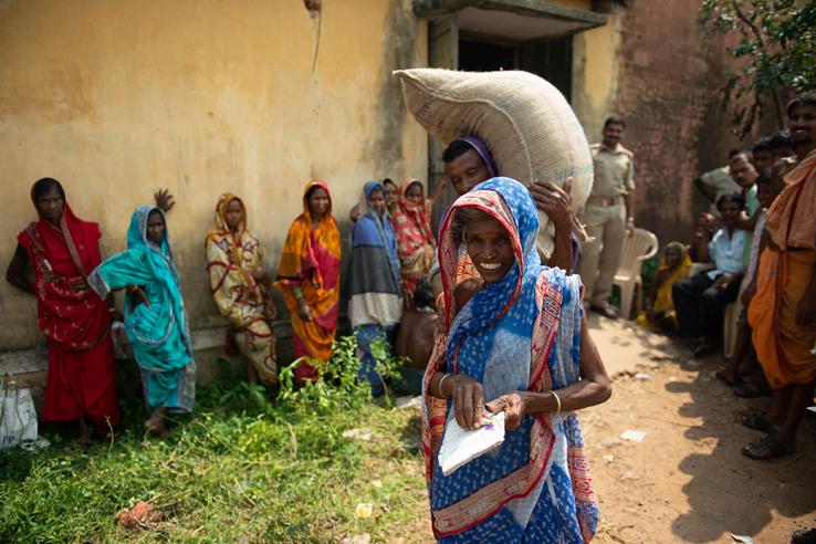 A woman with a bag of rice at a government grain distribution center in Odisha, India.