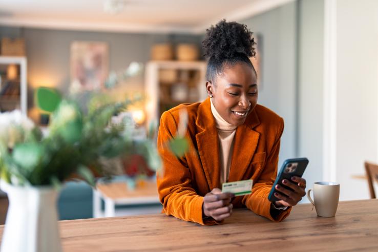 Woman holding credit card and phone