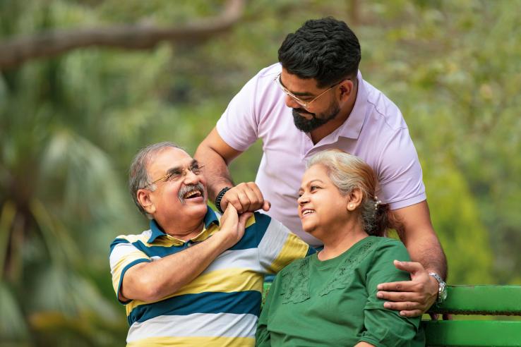 Man hugs his parents in a park