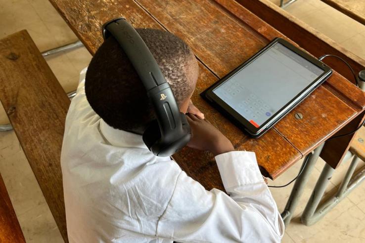 Student with headphones looking at a tablet