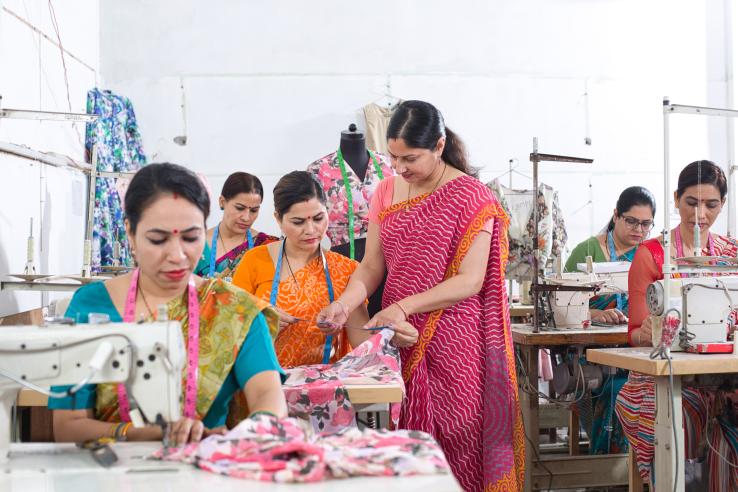 Woman textile worker checking garment stock at factory