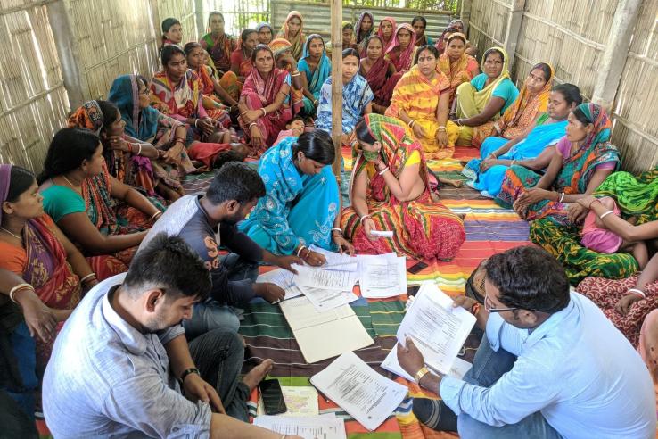 Group of men and women sitting on the floor working through surveys