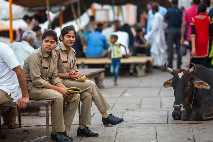 Two women police officers sit outdoors