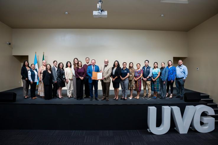 Group of people posing for picture after signing an agreement at UVG, Guatemala