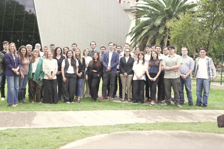 A group of J-PAL LAC staff and trainees pose in a group on grass