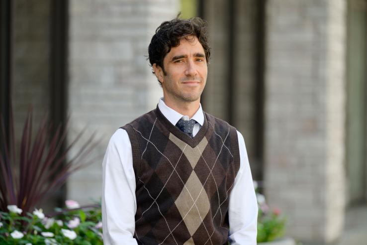 A photo of Jacob Wallace smiling with a blurred background.