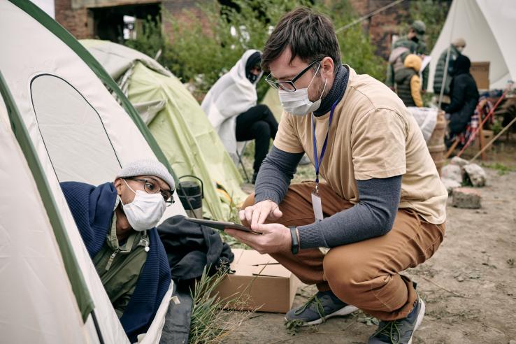 Volunteer asks man in tent questions