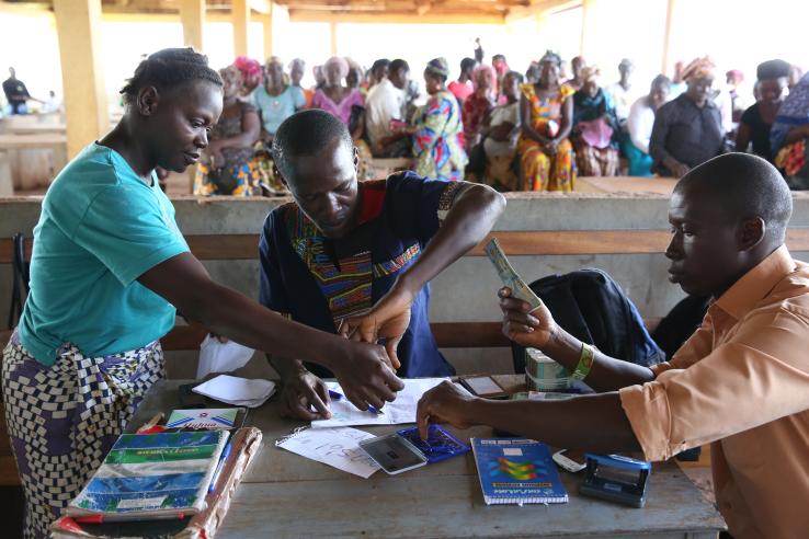 Freetown, Sierra Leone. Mymensing, Bangladesh. Patrick Lamboi (far right) and David A. Kargbo (center left), who work for Splash, make cash transfer payments to women.
