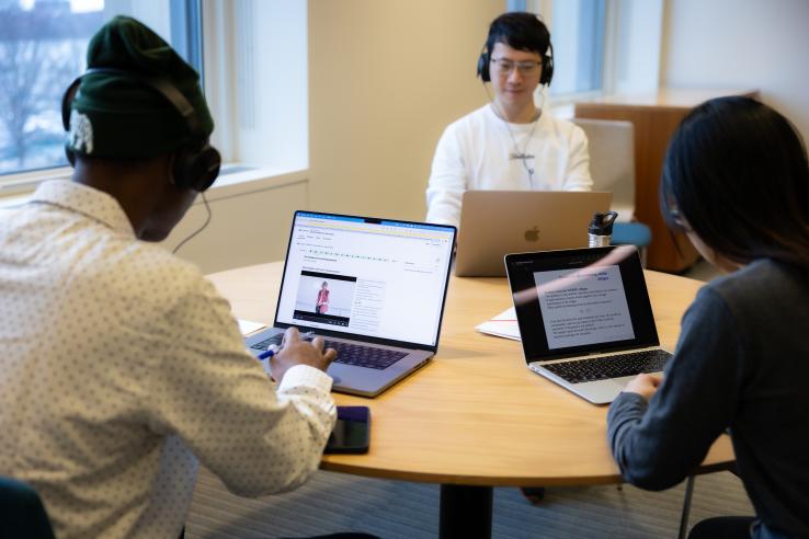DEDP master's students looking at their laptops