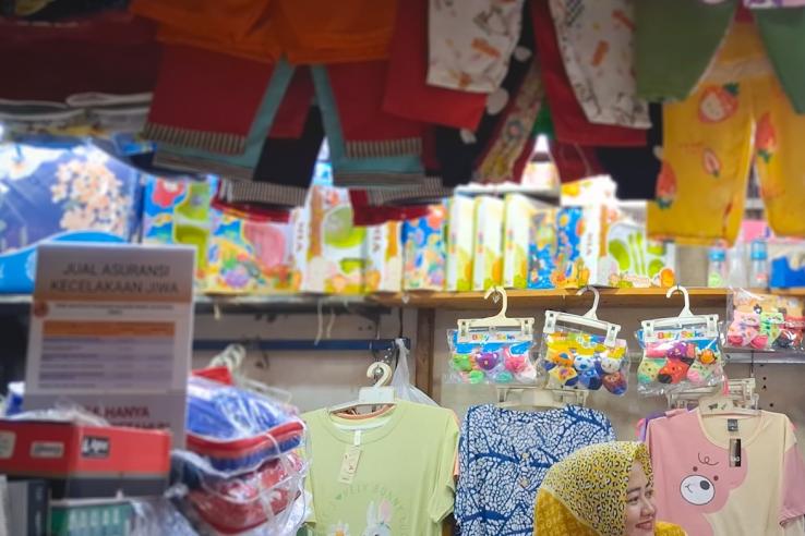 Woman in a store in Indonesia selling clothes