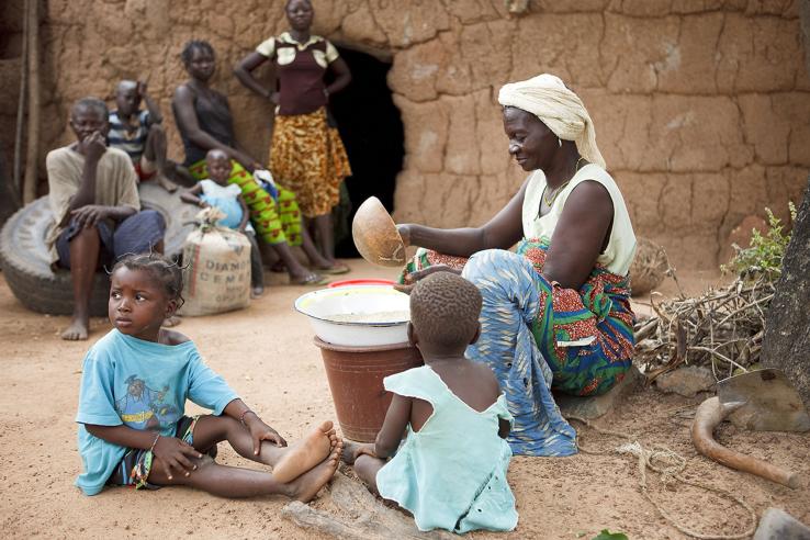 Woman sits with children.