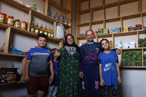 Family standing in front of shelves in their shop